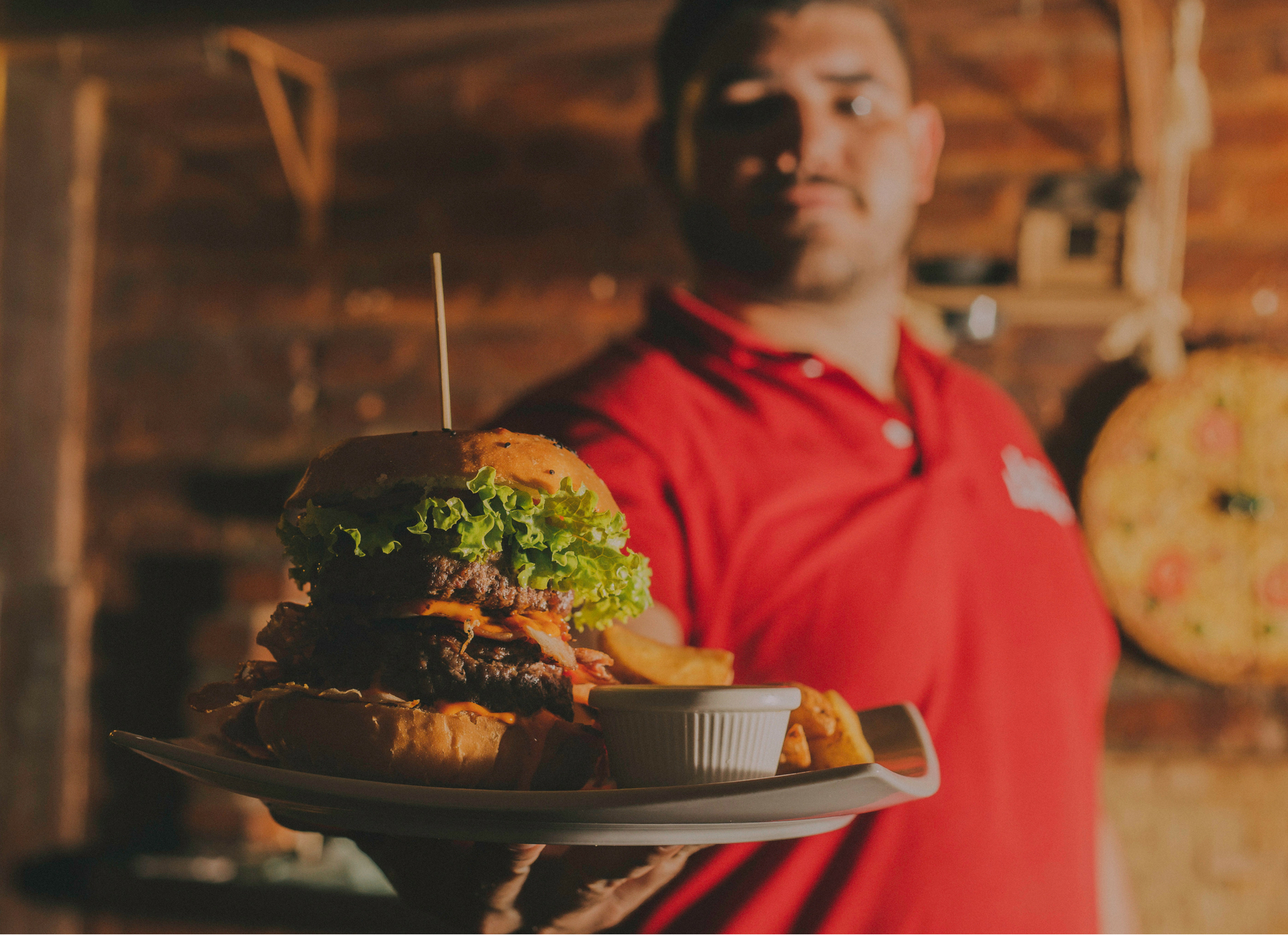 Restaurant server holding a burger on a plate