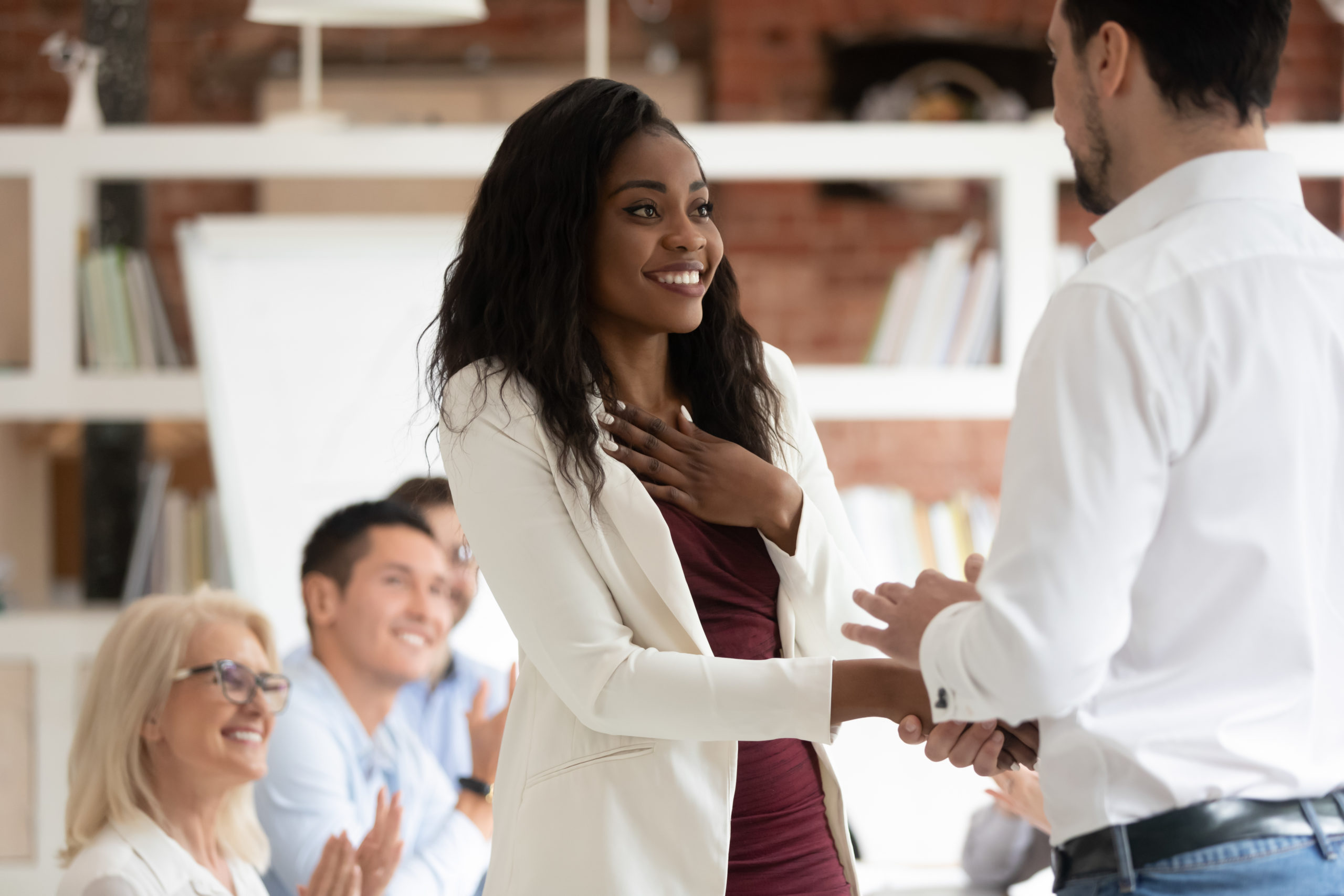 Happy female employee get rewarded handshake from boss